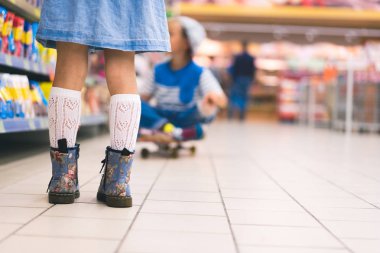 bir kadın çocuk süpermarkette ayakta kırpılmış görünümü