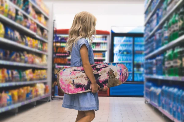 Anak Pirang Dengan Skateboard Berdiri Supermarket Dengan Rak Belakang — Stok Foto