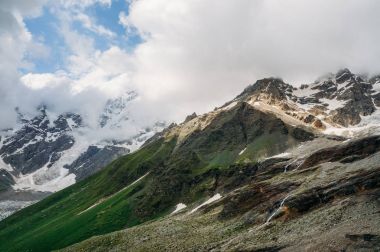 karlı dağ zirveleri çim ile görünümünü bulutlar, Ushguli, svaneti, Gürcistan altında yamaçlarında 