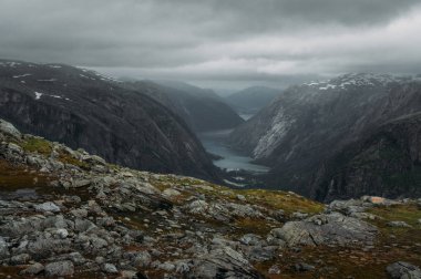 view of slope with stones and rocks and river on foot  on background, Norway, Hardangervidda National Park clipart