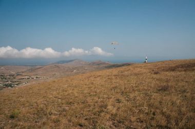 Parachute in the sky over field in hillside area of Crimea, Ukraine, May 2013 clipart