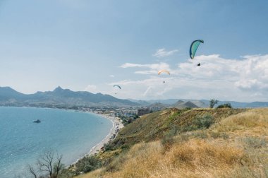 Mountainous landscape with paratroopers flying in the sky, Crimea, Ukraine, May 2013 clipart