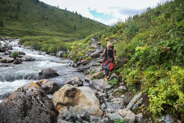 Genç backpacker Altay, Rusya'da Nehri yakınında yürüyüş