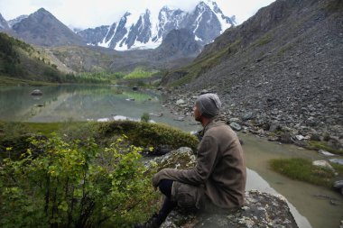 Side view of tourist resting in Himalayas mountains, Altai, Russia clipart