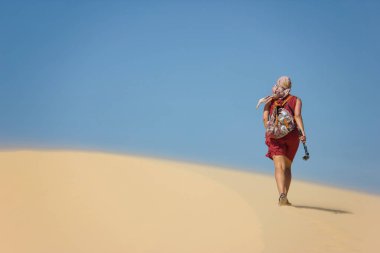 rear view of lonely woman with backpack walking in desert, Vietnam, Phan Thiet
