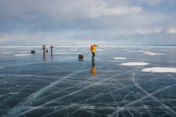 ロシア バイカル湖の中に氷の水の表面に立っている観光客のグループ  — 無料ストックフォト