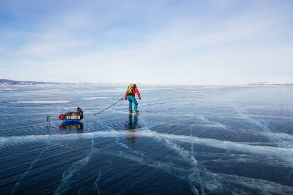 мужчина турист с рюкзаком ходьба по поверхности ледяной воды, Россия, озеро Байкал
 