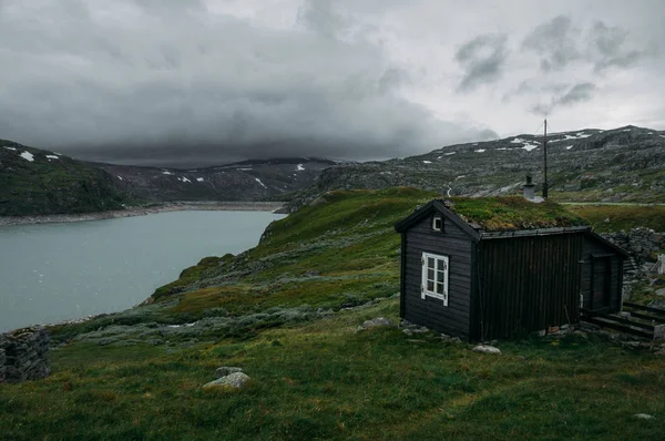 kırsal alan küçük gölet, Norveç, Hardangervidda'da Milli Parkı karşı yeşil çim ile evine