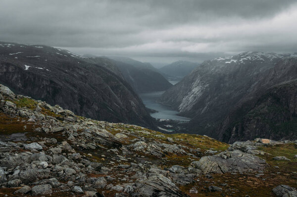 view of slope with stones and rocks and river on foot  on background, Norway, Hardangervidda National Park