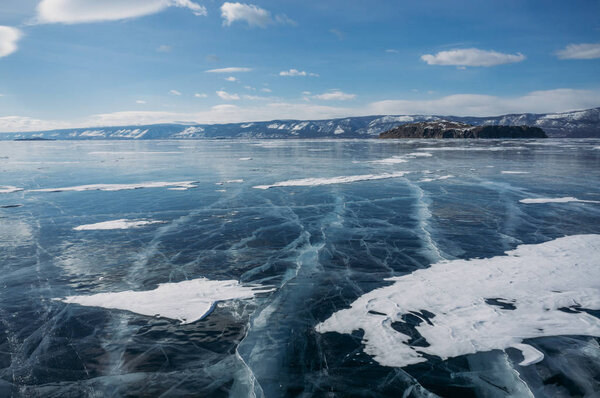 view of ice covered lake water and hills on background, Russia, Lake Baikal