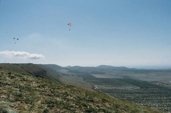 Parachutes in the sky over field in hillside area of Crimea, Ukraine, May 2013