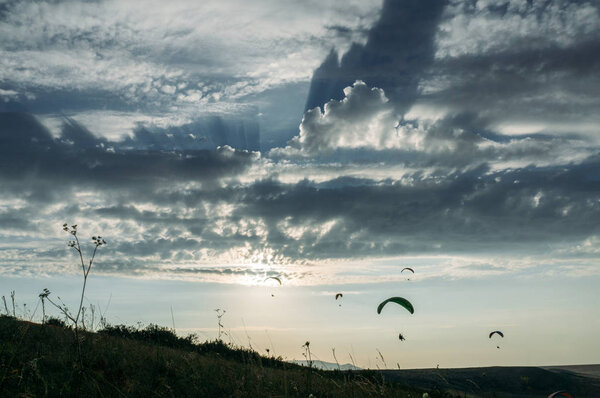 Парашютисты, скользящие в голубом небе над живописным пейзажем Крыма, Украина, май 2013 г.
