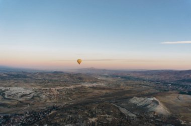 one hot air balloon flying Goreme national park, fairy chimneys, Cappadocia, Turkey clipart