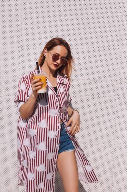 mango ile çizgili kırmızı gömlek güzel genç kadın sallamak içinde plastik bardak