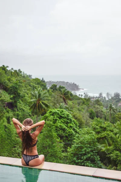 Rückansicht Eines Mädchens Das Swimmingpool Sitzt Und Den Tropischen Wald — kostenloses Stockfoto