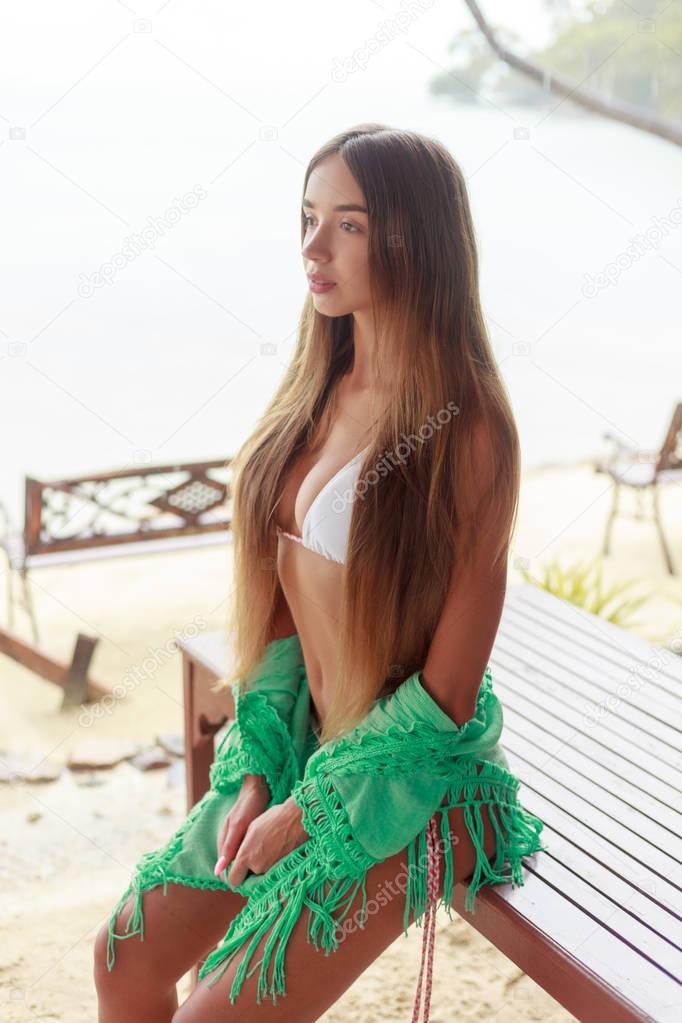 young girl in white bikini on tropical resort