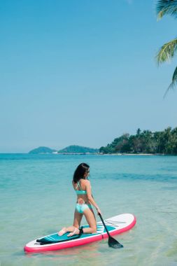 genç kız paddleboarding tropikal Resort denizde