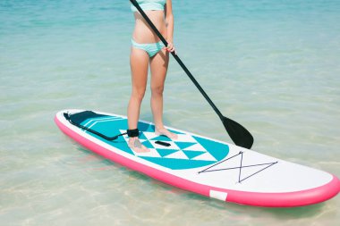 kadın kırpılmış görünümü tropikal resort denizde kürek tahtada ayağa '