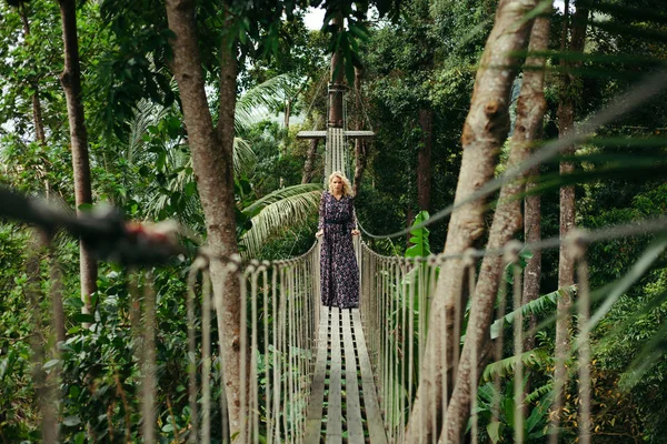 Ελκυστική Σοβαρή Γυναίκα Στο Φόρεμα Στέκεται Στην Πεζογέφυρα Στη Ζούγκλα — Φωτογραφία Αρχείου