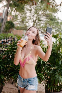selfie akıllı telefon ve içme ile kokteyl alarak çekici kız