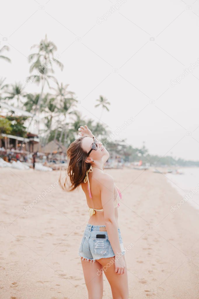 beautiful girl shaking hair on sandy beach 