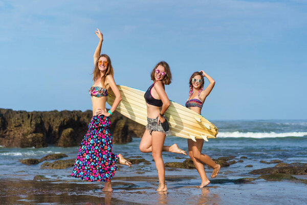 group of happy young women with surfboard on beach