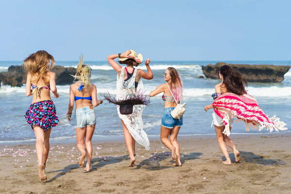 rear view of group of women running at sea