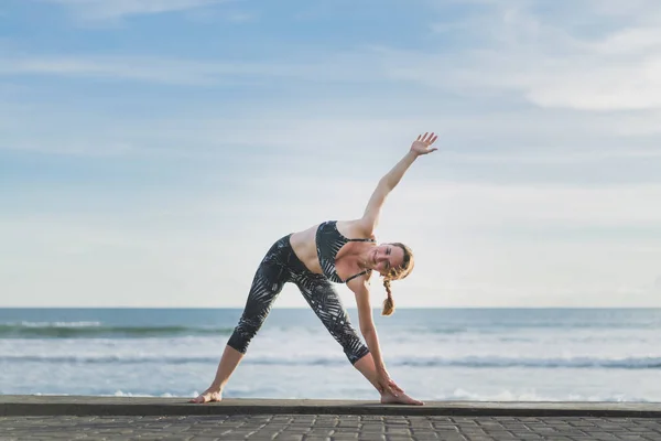 Mujer Practicando Yoga Extended Triangle Pose Con Océano Cielo Azul — Foto de Stock