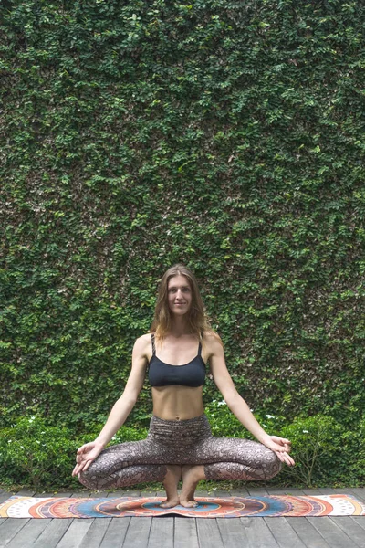 Mujer Joven Forma Practicando Yoga Squatting Toe Balance Pose Haciendo — Foto de stock gratis