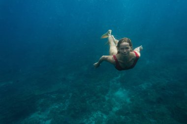 Sualtı yüzme takım elbise ve okyanusta yalnız dalış palet içinde genç kadın fotoğrafı