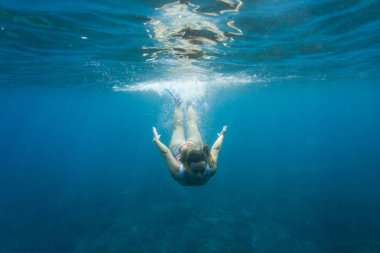 sualtı dalış okyanusta yalnız yüzme elbiseli genç kadın fotoğrafı