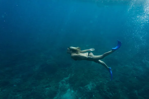 ビキニと単独で海でのダイビング足ひれの女性の側面図 — ストック写真