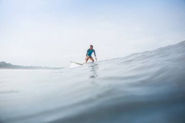 Sportif mayo binme surfboard okyanusta genç kadın