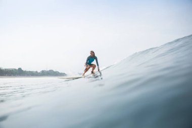 Sportif mayo binme surfboard okyanusta çekici genç kadın