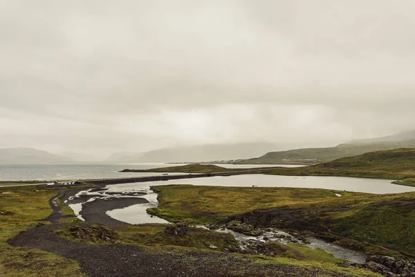 Increíble paisaje con río y colinas cubiertas de hierba en Islandia - foto de stock