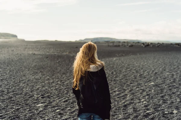 Vista posterior de la mujer joven mirando hermoso paisaje icelandés salvaje - foto de stock