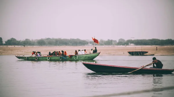 Personas en barcos que fluyen en el río Ganges en Varanasi, India - foto de stock