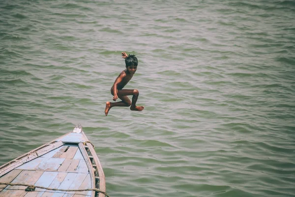 Adorable petit garçon sautant du bateau à Varanasi, Inde — Photo de stock