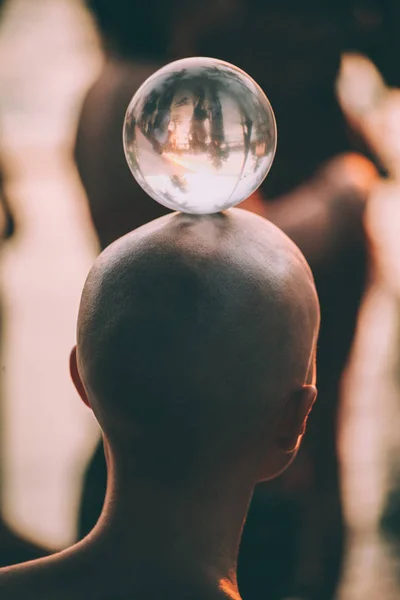 Close-up back view of young man standing with glass ball on head, Goa — Stock Photo