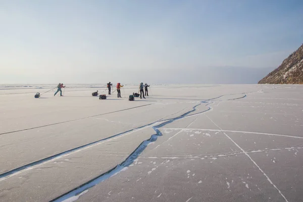 Group of tourists walking on ice water surface during daytime, russia, lake baikal — Stock Photo