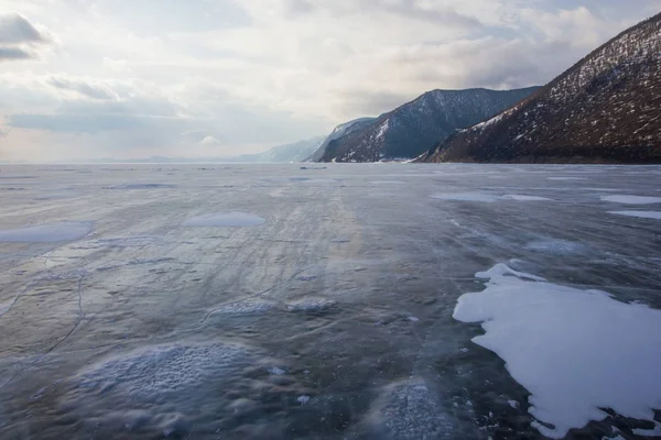 Вид озера с ледяной поверхностью и скальными образованиями на берегу, Россия, озеро Байкал — стоковое фото