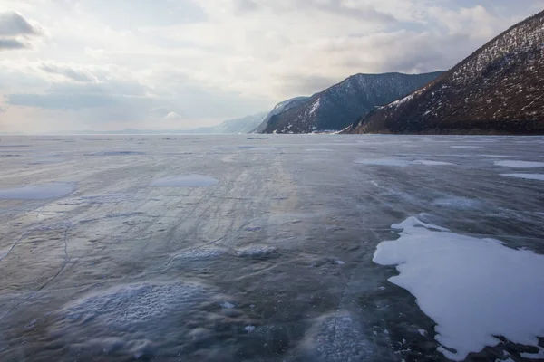 View of lake with ice surface and rocks formations on shore ,russia, lake baikal — Stock Photo