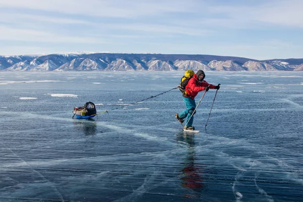 Senderista masculino con mochila caminando sobre la superficie del agua de hielo,, Rusia, lago baikal - foto de stock