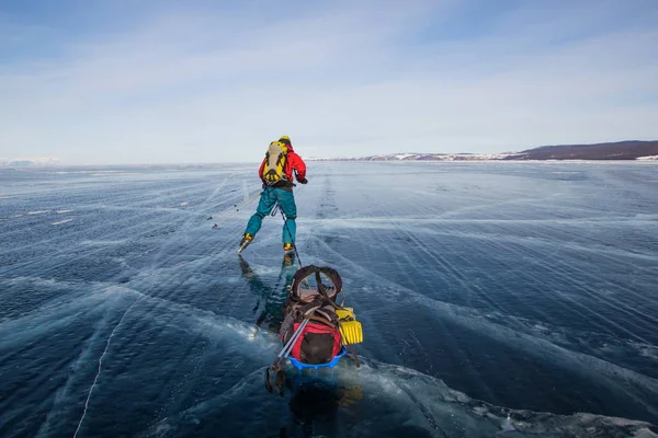 Caminhante masculino com mochila andando na superfície da água gelada, Rússia, lago baikal — Fotografia de Stock