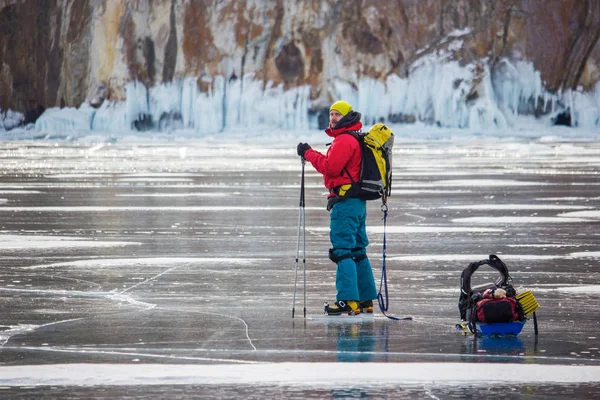 Людина з рюкзака переживає вода з льодом поверхні і пагорбів на тлі, Росія, озеро Байкал — стокове фото