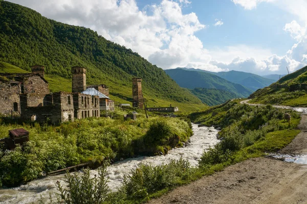 Old weathered buildings against small river stream against hills, Ushguli, svaneti, georgia — Stock Photo