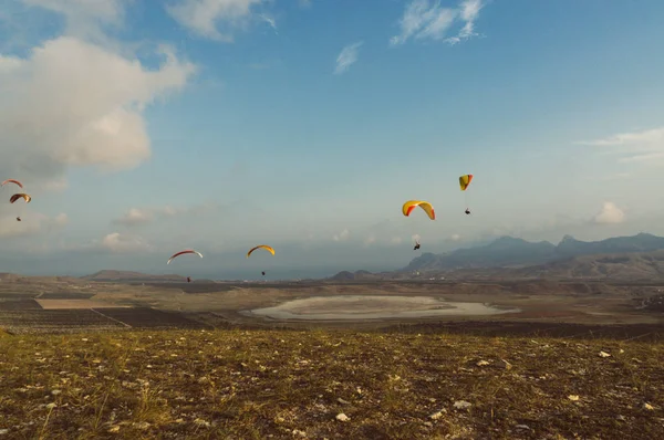 Parachutists gliding in blue sky over scenic landscape of Crimea, Ukraine, May 2013 — Stock Photo