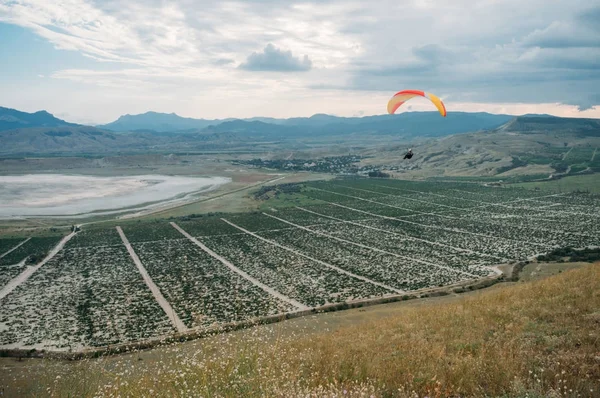 Paracaídas en el cielo sobre el campo en la zona de la ladera de Crimea, Ucrania, mayo 2013 - foto de stock