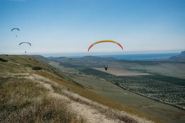 Paisaje montañoso con paracaidistas volando en el cielo, Crimea, Ucrania, mayo 2013 - foto de stock