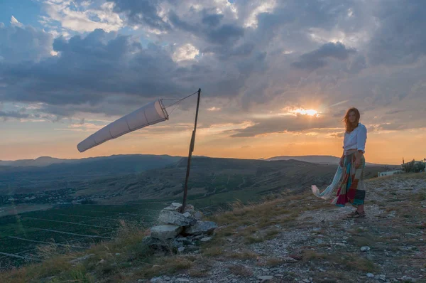 Woman walking in beautiful mountainous landscape with windsock waving in Crimea, Ukraine, May 2013 — Stock Photo